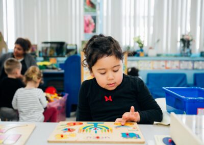 TEBH ECC preschooler playing with a wooden puzzle