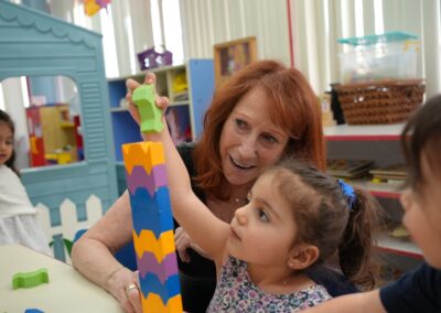TEBH ECC teacher with student playing with blocks